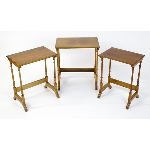 1741 - A nest of three early 20thC walnut tables each with a rectangular top, four turned pillar supports a... 