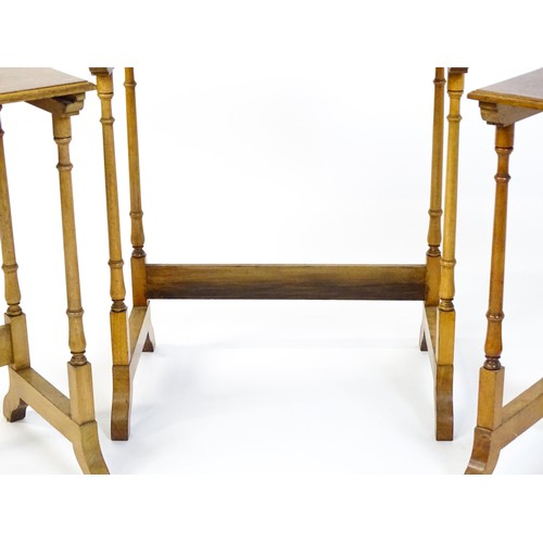 1741 - A nest of three early 20thC walnut tables each with a rectangular top, four turned pillar supports a... 