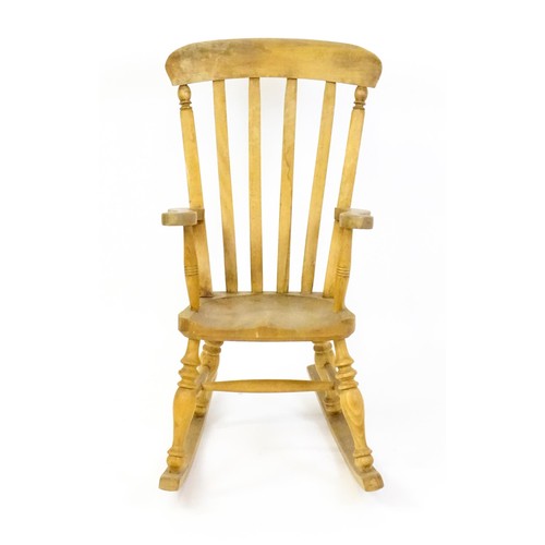 1742 - A mid 20thC child's lathe back Windsor rocking chair, with swept arms, a shaped seat and raised on f... 