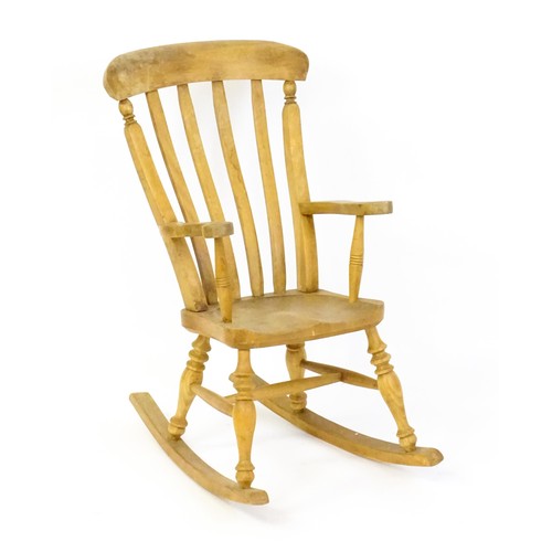 1742 - A mid 20thC child's lathe back Windsor rocking chair, with swept arms, a shaped seat and raised on f... 