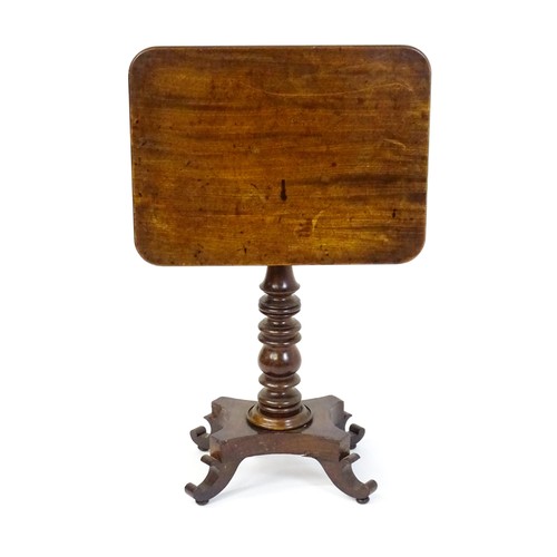 1744 - A mid 19thC mahogany occasional table with a rectangular tilt top above a turned pedestal and quad f... 