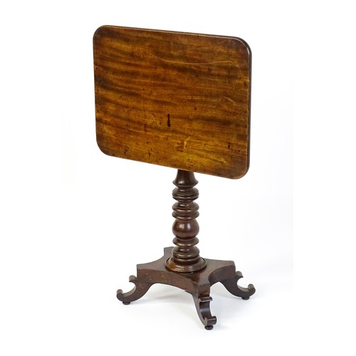 1744 - A mid 19thC mahogany occasional table with a rectangular tilt top above a turned pedestal and quad f... 