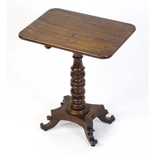 1744 - A mid 19thC mahogany occasional table with a rectangular tilt top above a turned pedestal and quad f... 