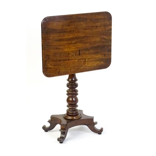 1744 - A mid 19thC mahogany occasional table with a rectangular tilt top above a turned pedestal and quad f... 