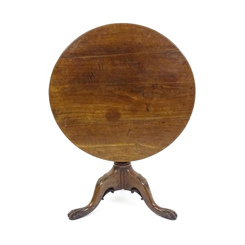 1748 - A 18thC mahogany tripod table with a circular table top above a fluted pedestal and three cabriole l... 