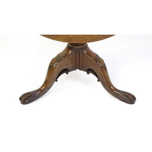 1748 - A 18thC mahogany tripod table with a circular table top above a fluted pedestal and three cabriole l... 