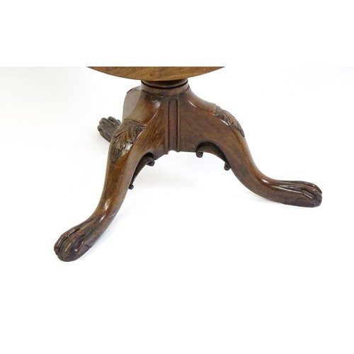 1748 - A 18thC mahogany tripod table with a circular table top above a fluted pedestal and three cabriole l... 