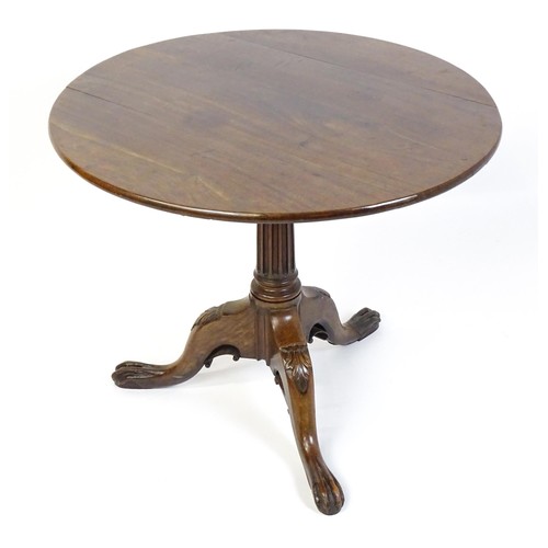 1748 - A 18thC mahogany tripod table with a circular table top above a fluted pedestal and three cabriole l... 