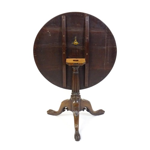 1748 - A 18thC mahogany tripod table with a circular table top above a fluted pedestal and three cabriole l... 