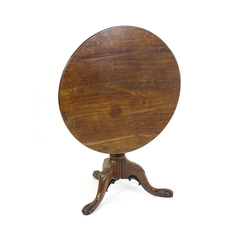 1748 - A 18thC mahogany tripod table with a circular table top above a fluted pedestal and three cabriole l... 