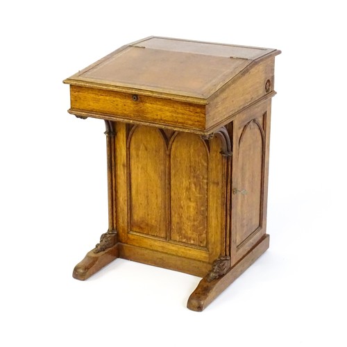 1752 - A 19thC oak Davenport with a leather inset writing slope above a panelled front and sides with Gothi... 