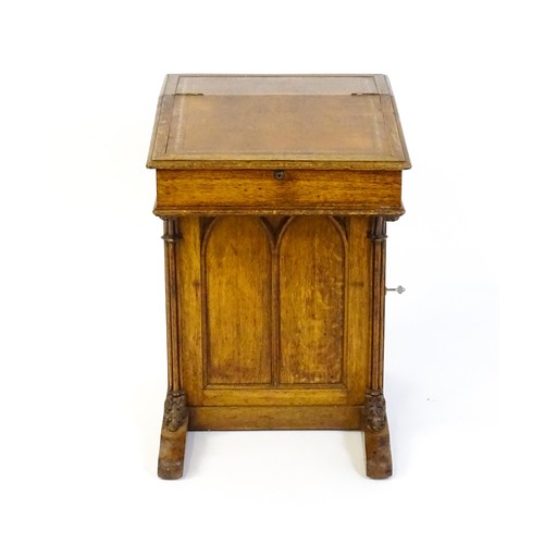 1752 - A 19thC oak Davenport with a leather inset writing slope above a panelled front and sides with Gothi... 