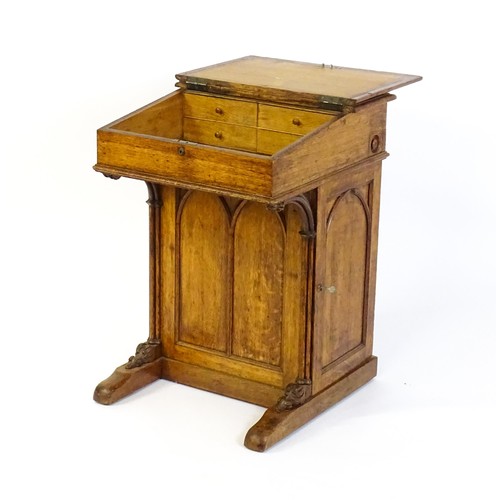 1752 - A 19thC oak Davenport with a leather inset writing slope above a panelled front and sides with Gothi... 