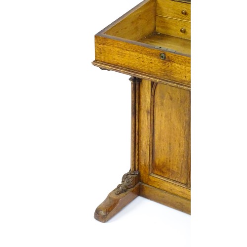 1752 - A 19thC oak Davenport with a leather inset writing slope above a panelled front and sides with Gothi... 