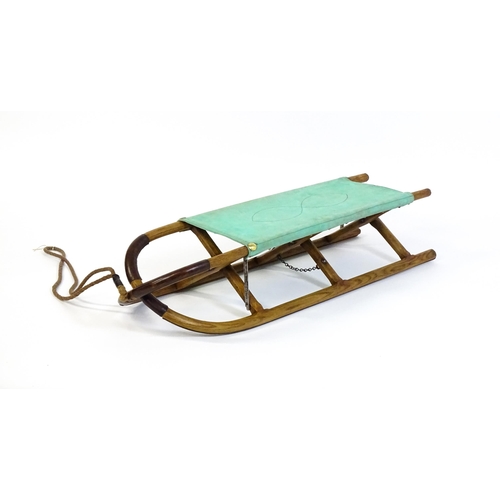 1261 - A 20thC small folding stretcher / sledge with an x-frame. Approx. 52