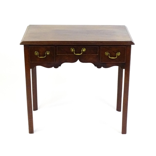 1528 - A Georgian mahogany lowboy with a moulded top above three short drawers and raised on four chamfered... 