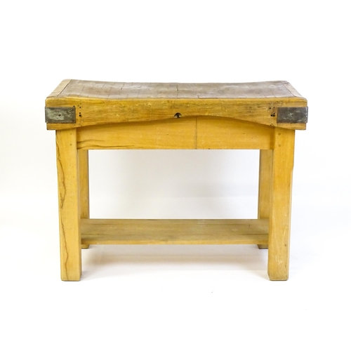 1540 - An early 20thC butchers block on a later stand, the block having corner brackets and raised on a peg... 