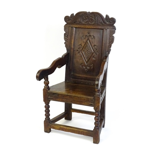 1542 - A 17thC oak Wainscot chair with a scrolled, floral cresting rail above a lozenge carved backrest and... 