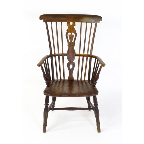 1543 - A 19thC Windsor chair with a double bow back rest and elm seat raised on turned tapering legs united... 