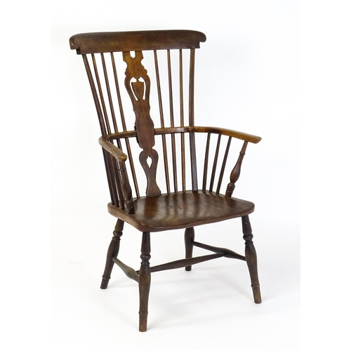 1543 - A 19thC Windsor chair with a double bow back rest and elm seat raised on turned tapering legs united... 