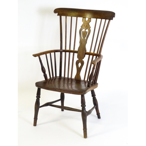 1543 - A 19thC Windsor chair with a double bow back rest and elm seat raised on turned tapering legs united... 