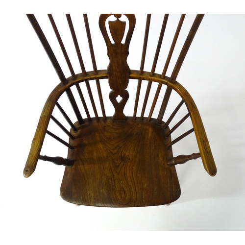 1543 - A 19thC Windsor chair with a double bow back rest and elm seat raised on turned tapering legs united... 