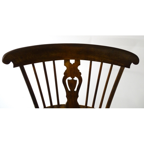 1543 - A 19thC Windsor chair with a double bow back rest and elm seat raised on turned tapering legs united... 