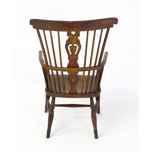 1543 - A 19thC Windsor chair with a double bow back rest and elm seat raised on turned tapering legs united... 