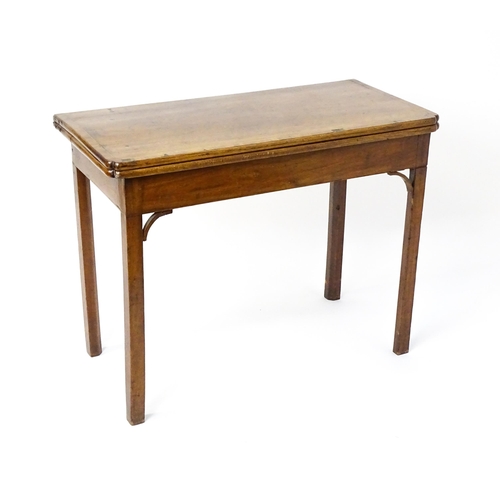 1548 - A 19thC walnut card table with a crossbanded top having re-entrant corners, the top hinging open to ... 