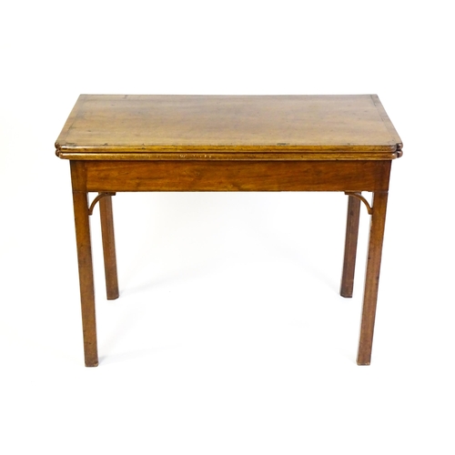 1548 - A 19thC walnut card table with a crossbanded top having re-entrant corners, the top hinging open to ... 