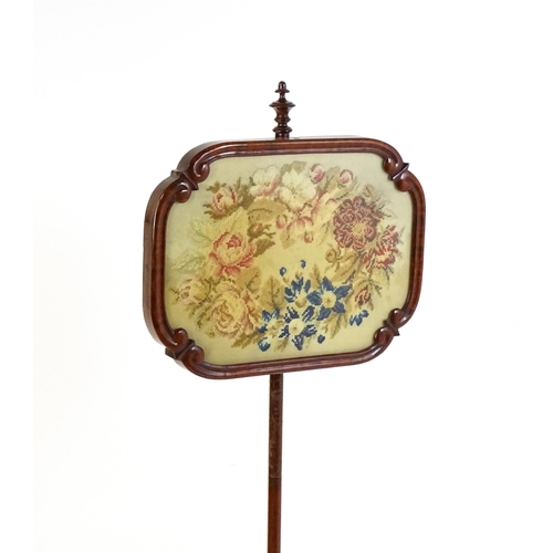 1550 - A mid 19thC mahogany pole screen, with a glazed adjustable screen having a needlework centre and re-... 