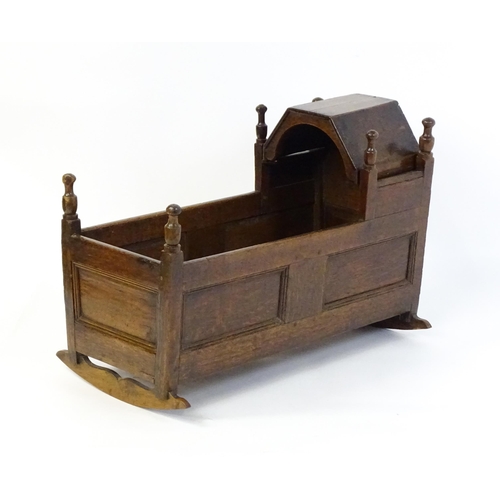 1553 - An 18thC oak crib of peg jointed construction with a hinged hood. 34