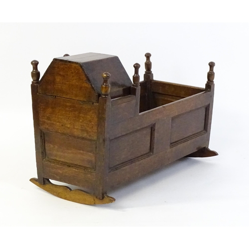 1553 - An 18thC oak crib of peg jointed construction with a hinged hood. 34