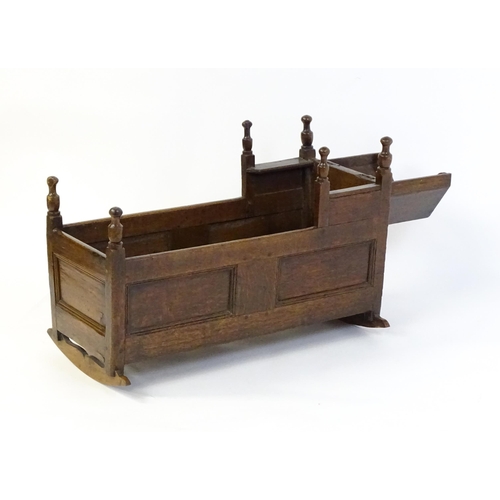 1553 - An 18thC oak crib of peg jointed construction with a hinged hood. 34