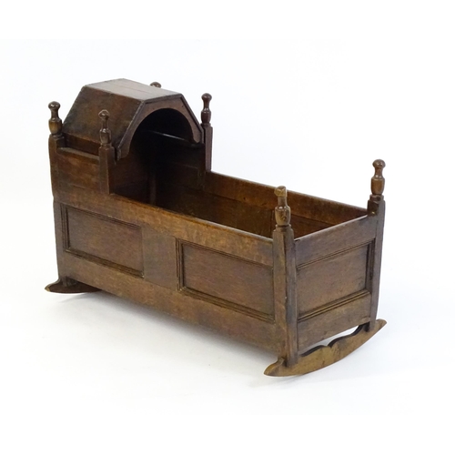 1553 - An 18thC oak crib of peg jointed construction with a hinged hood. 34