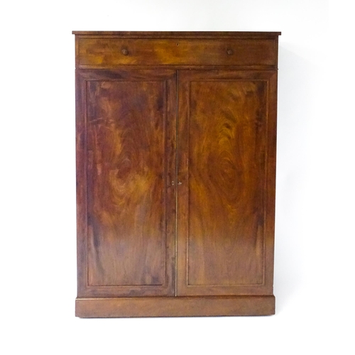 1554 - An early 19thC mahogany linen press with a single long drawer having floral carved knobs above two p... 