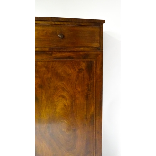 1554 - An early 19thC mahogany linen press with a single long drawer having floral carved knobs above two p... 