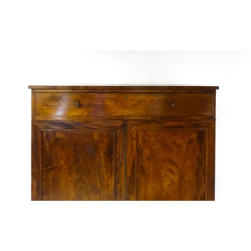 1554 - An early 19thC mahogany linen press with a single long drawer having floral carved knobs above two p... 