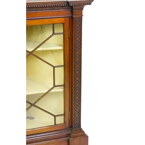 1555 - An early 19thC mahogany corner cupboard with a dentil moulded frieze and quatrefoil blink fretwork c... 