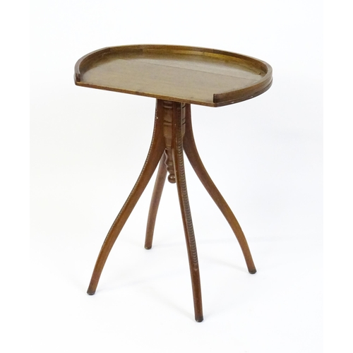 1556 - An Aesthetic period mahogany occasional table with a horseshoe shaped top raised on a pedestal base ... 