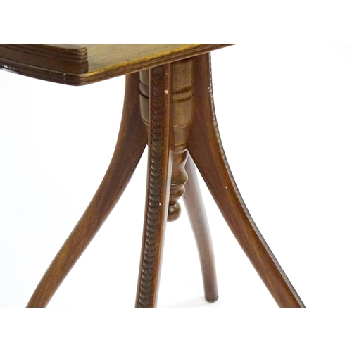 1556 - An Aesthetic period mahogany occasional table with a horseshoe shaped top raised on a pedestal base ... 