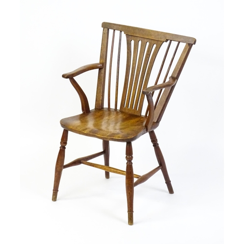 1558 - A late Georgian Windsor chair with a fanned back splat, a shaped seat and raised on turned tapering ... 