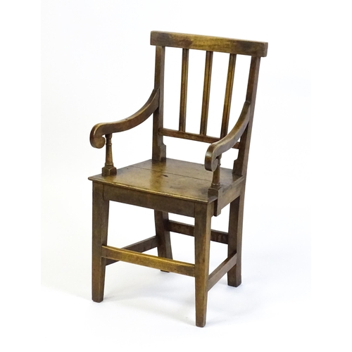 1560 - A Georgian child's chair with reeded back slats, scrolled arms and raised on tapering legs united by... 