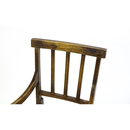 1560 - A Georgian child's chair with reeded back slats, scrolled arms and raised on tapering legs united by... 