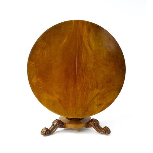 1564 - A 19thC mahogany tilt top breakfast table with a carved frieze above a turned and carved pedestal ba... 