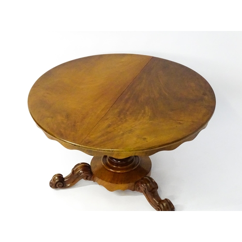 1564 - A 19thC mahogany tilt top breakfast table with a carved frieze above a turned and carved pedestal ba... 