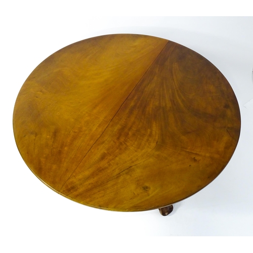 1564 - A 19thC mahogany tilt top breakfast table with a carved frieze above a turned and carved pedestal ba... 