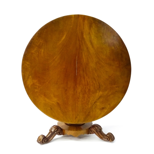 1564 - A 19thC mahogany tilt top breakfast table with a carved frieze above a turned and carved pedestal ba... 