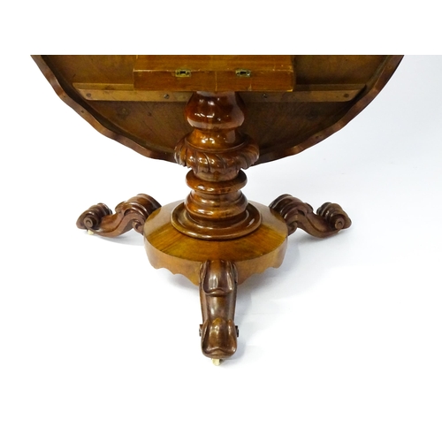 1564 - A 19thC mahogany tilt top breakfast table with a carved frieze above a turned and carved pedestal ba... 