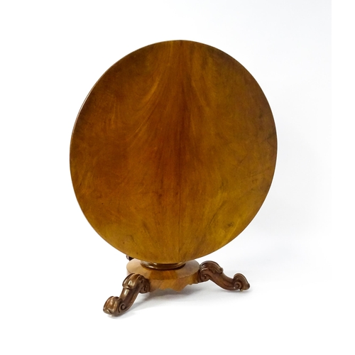 1564 - A 19thC mahogany tilt top breakfast table with a carved frieze above a turned and carved pedestal ba... 